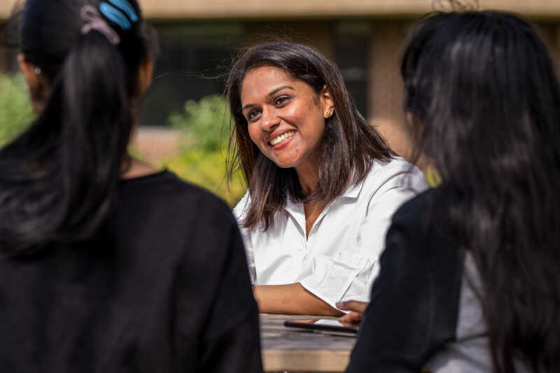 Image shows a young woman listening intently and smiling