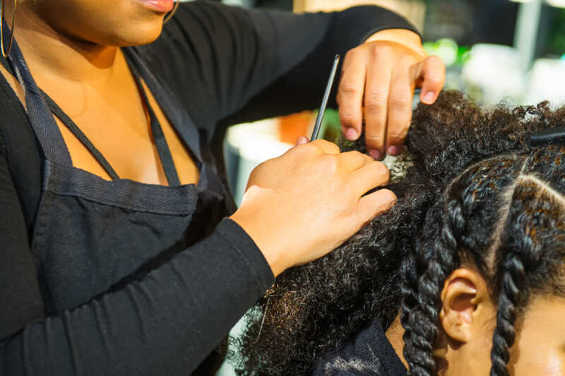 Someone having their hair put in twists