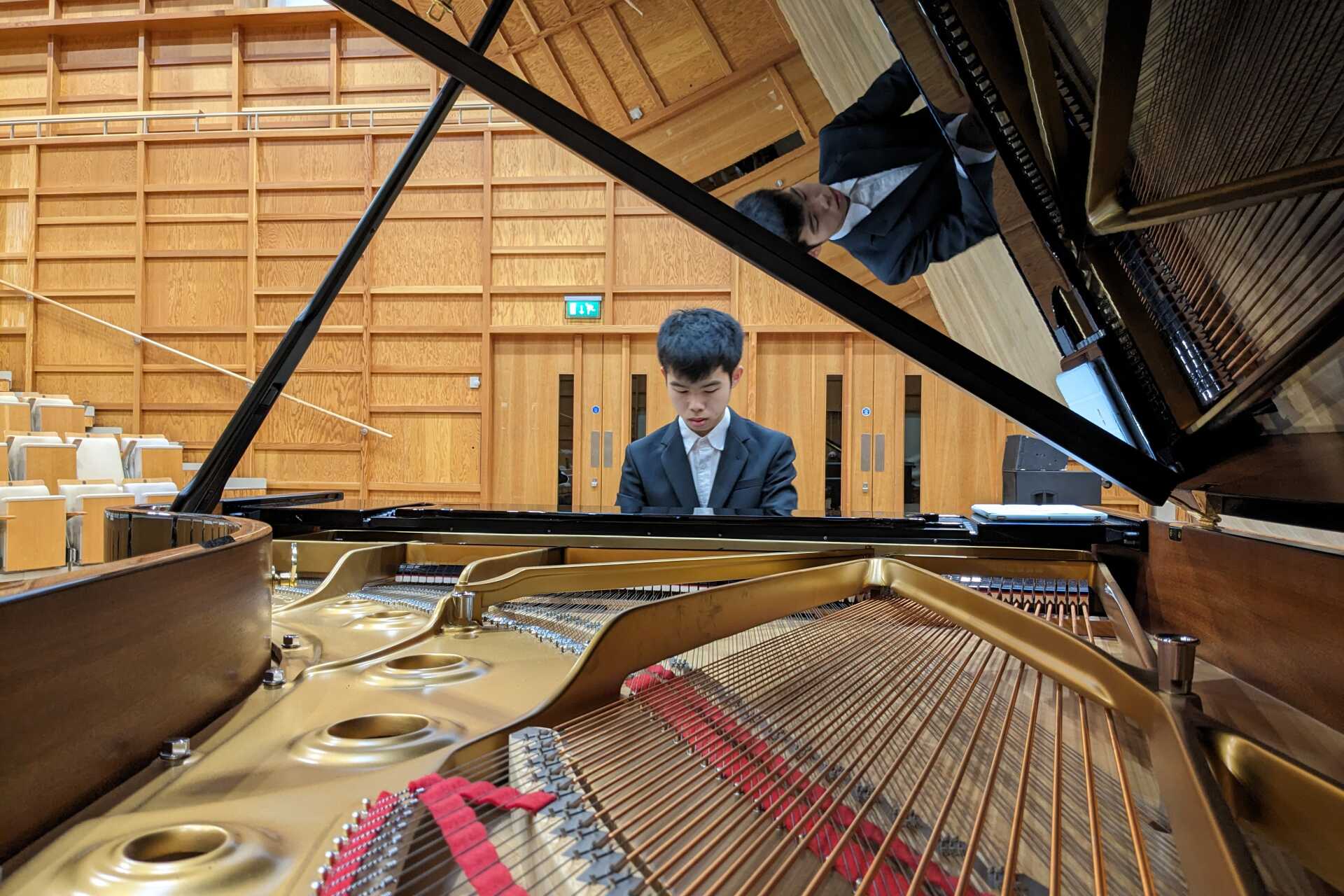Photo of male pianist playing a grand piano