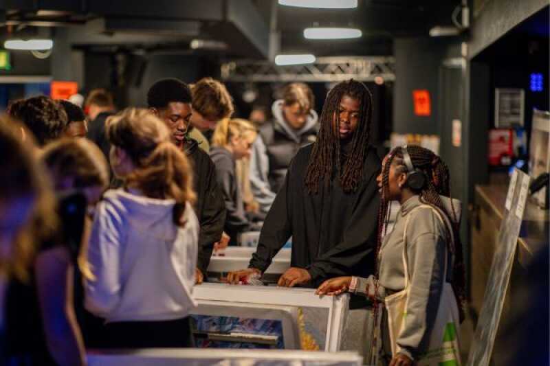 A group of students looking over a poster stall