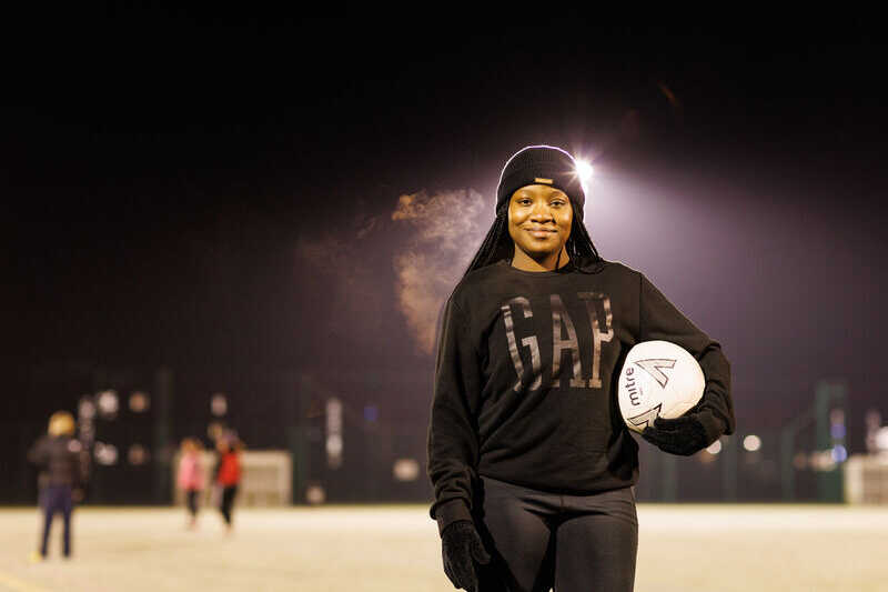 Female footballer holding a football under one arm