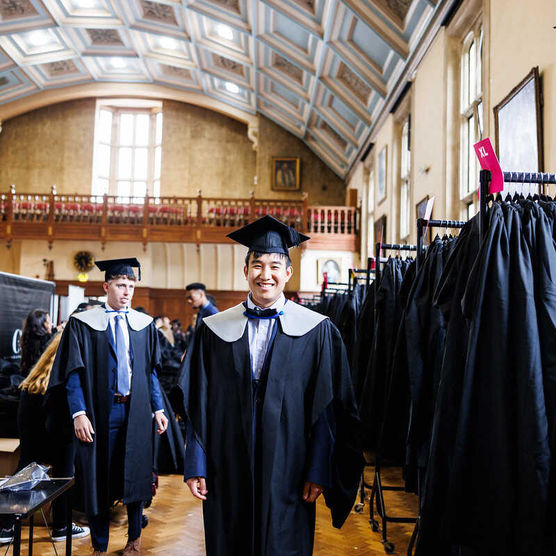 student and racks of gowns