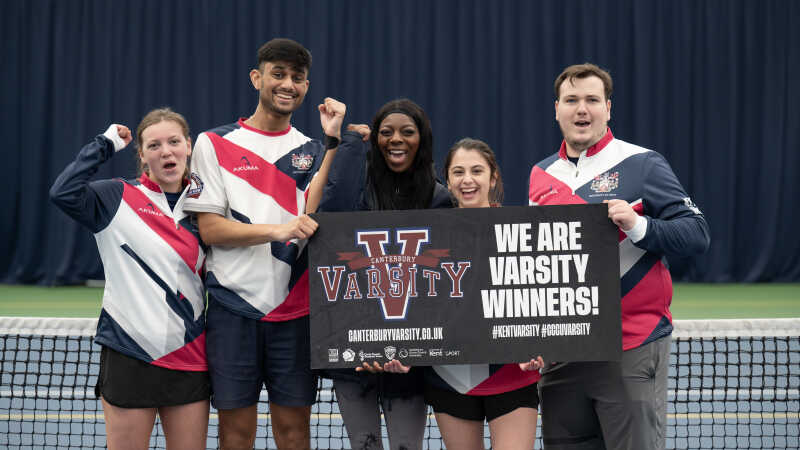 Group of students holding a Varsity banner.