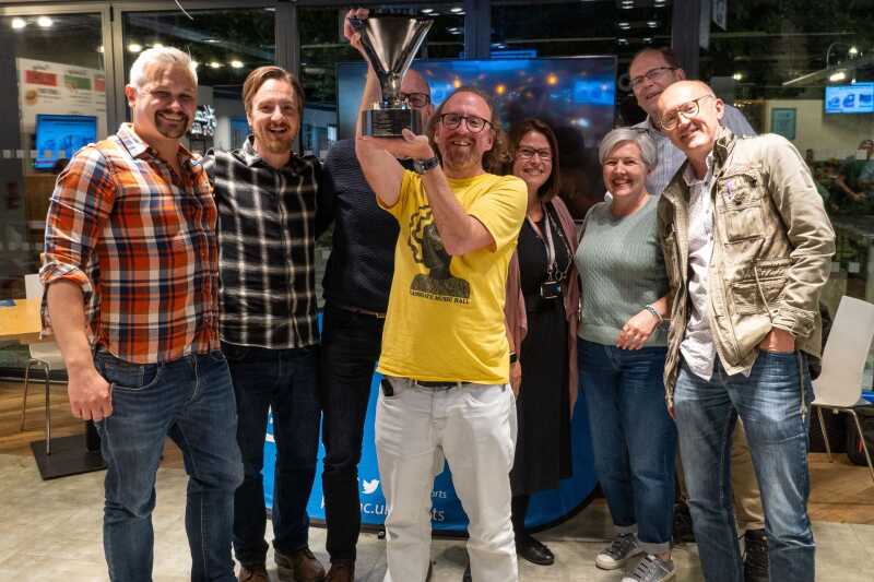 A group of people holding up a trophy