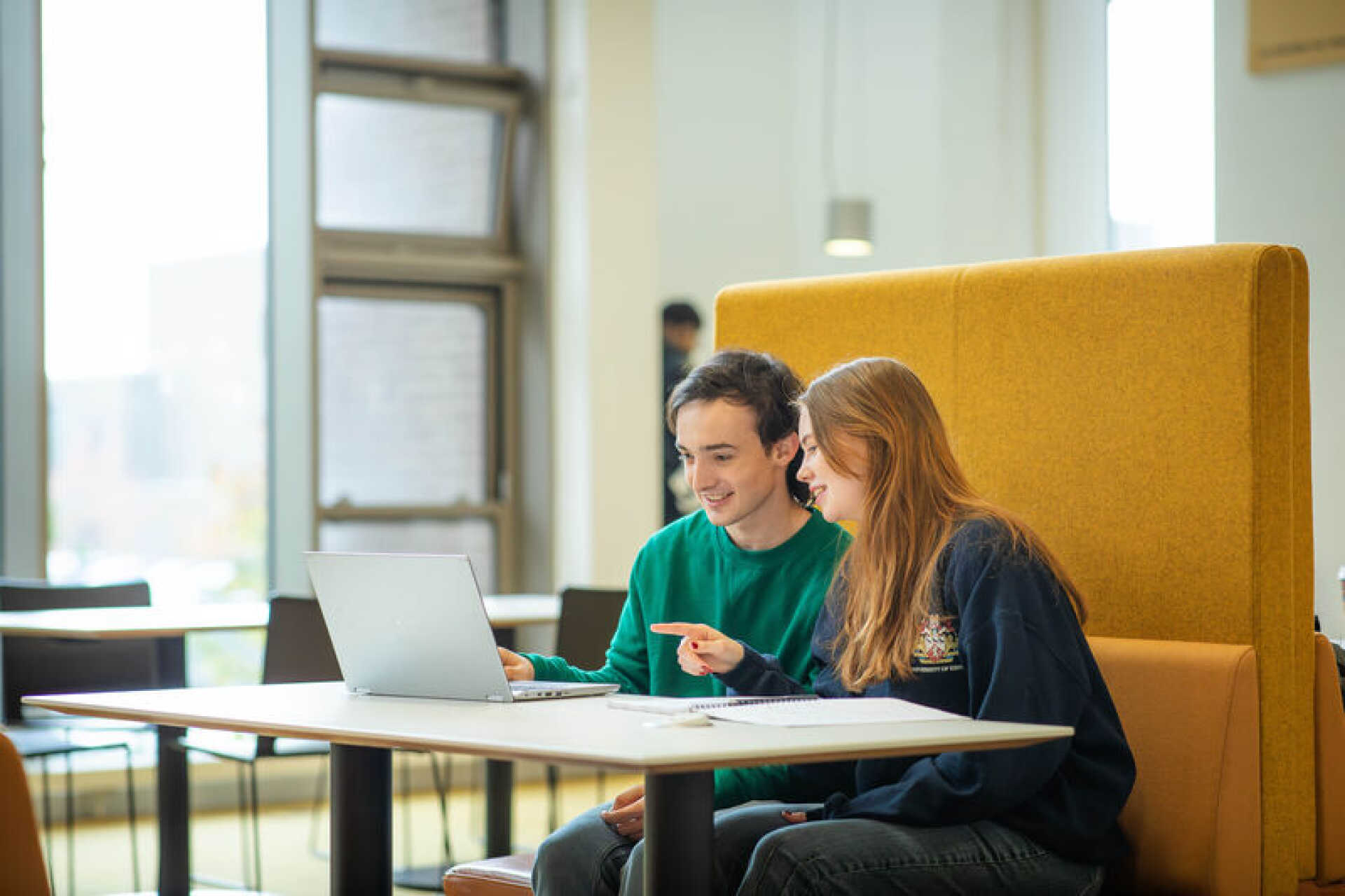 Two Kent students writing at a laptop