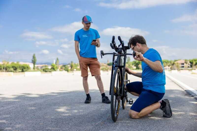 Two men working on a bike outside