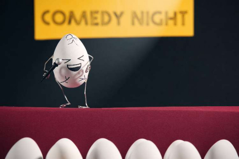 A personified egg as a stand-up comic 'cracking up' in a comedy club
