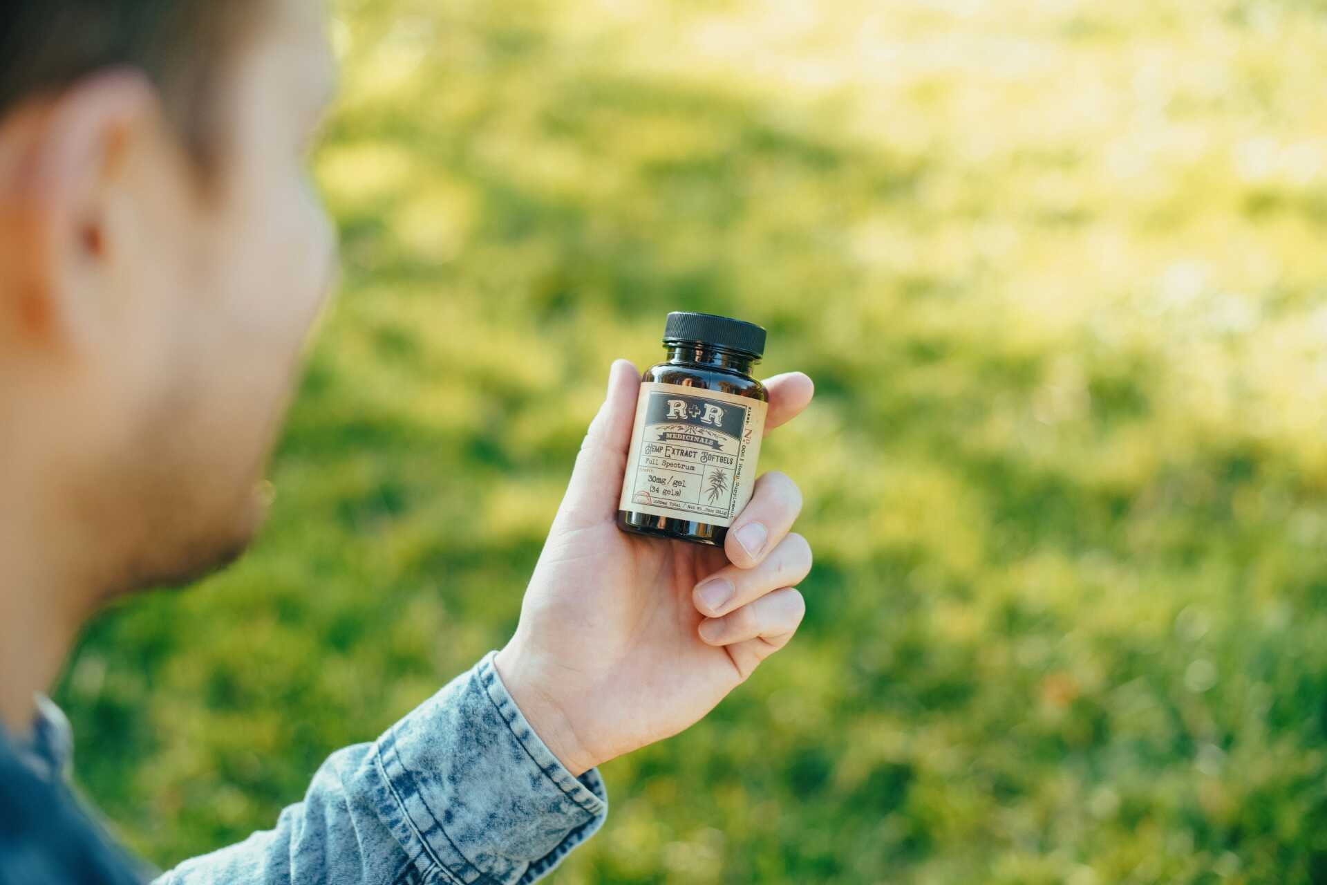 A man looking at a bottle of medicine