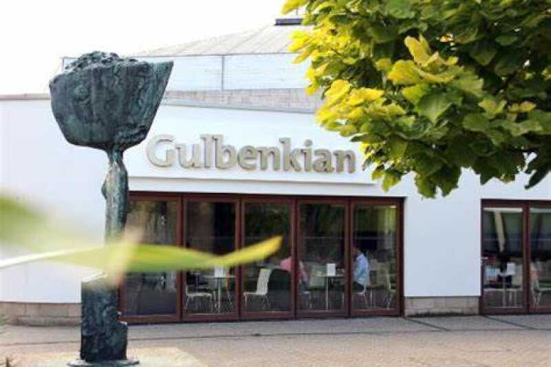 Image shows a white building with the words Gulbenkian above glass doors