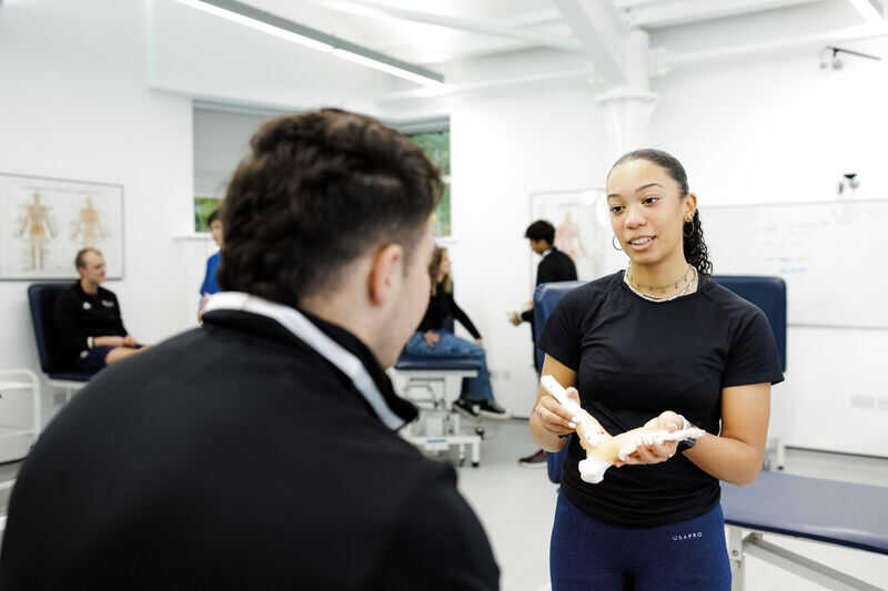 A student examining an ankle joint.