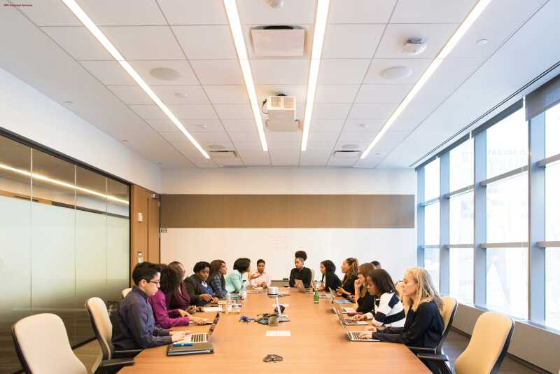 a group of professionals sitting around a table in a conference room