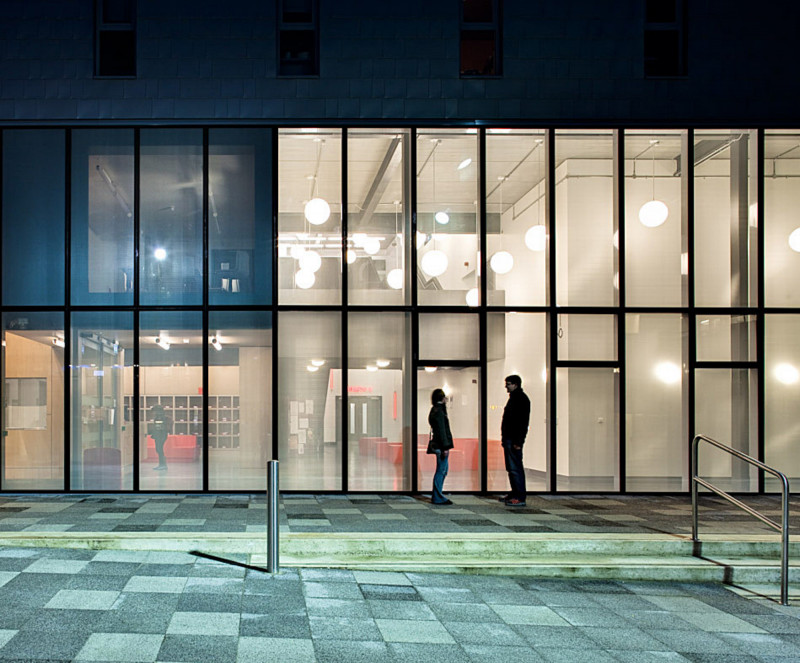 Two people standing in front of the Jarman building at night