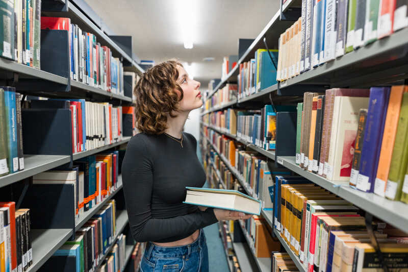 Students looking at bookshelves