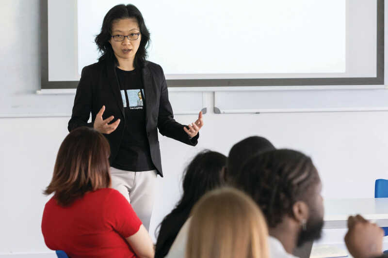 Image shows a seminar leader speaking to students.