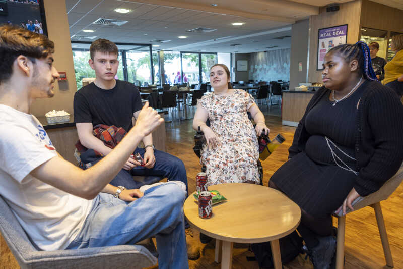 Image shows people sitting in a cafe and talking