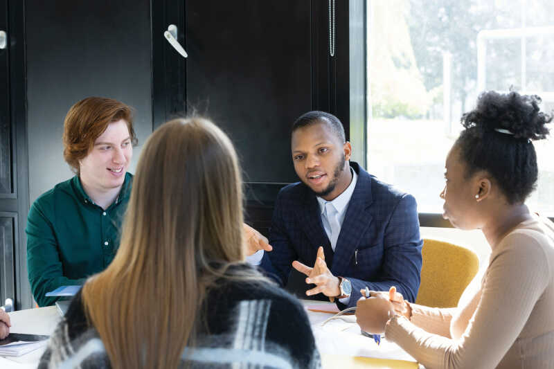 Image shows a group of people talking