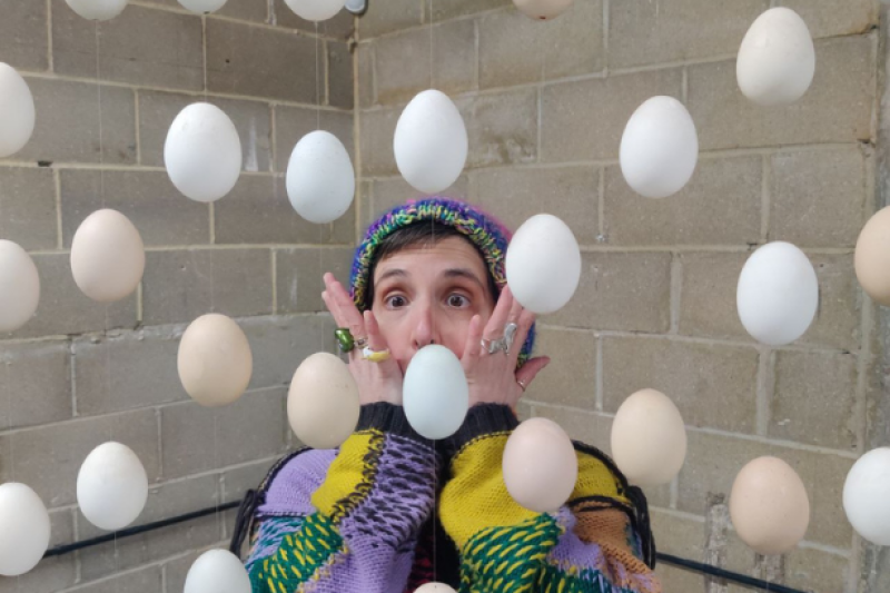 Image shows a person staring at eggs that are floating in the air