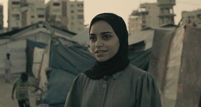 A person in Gaza, standing near makeshift tents