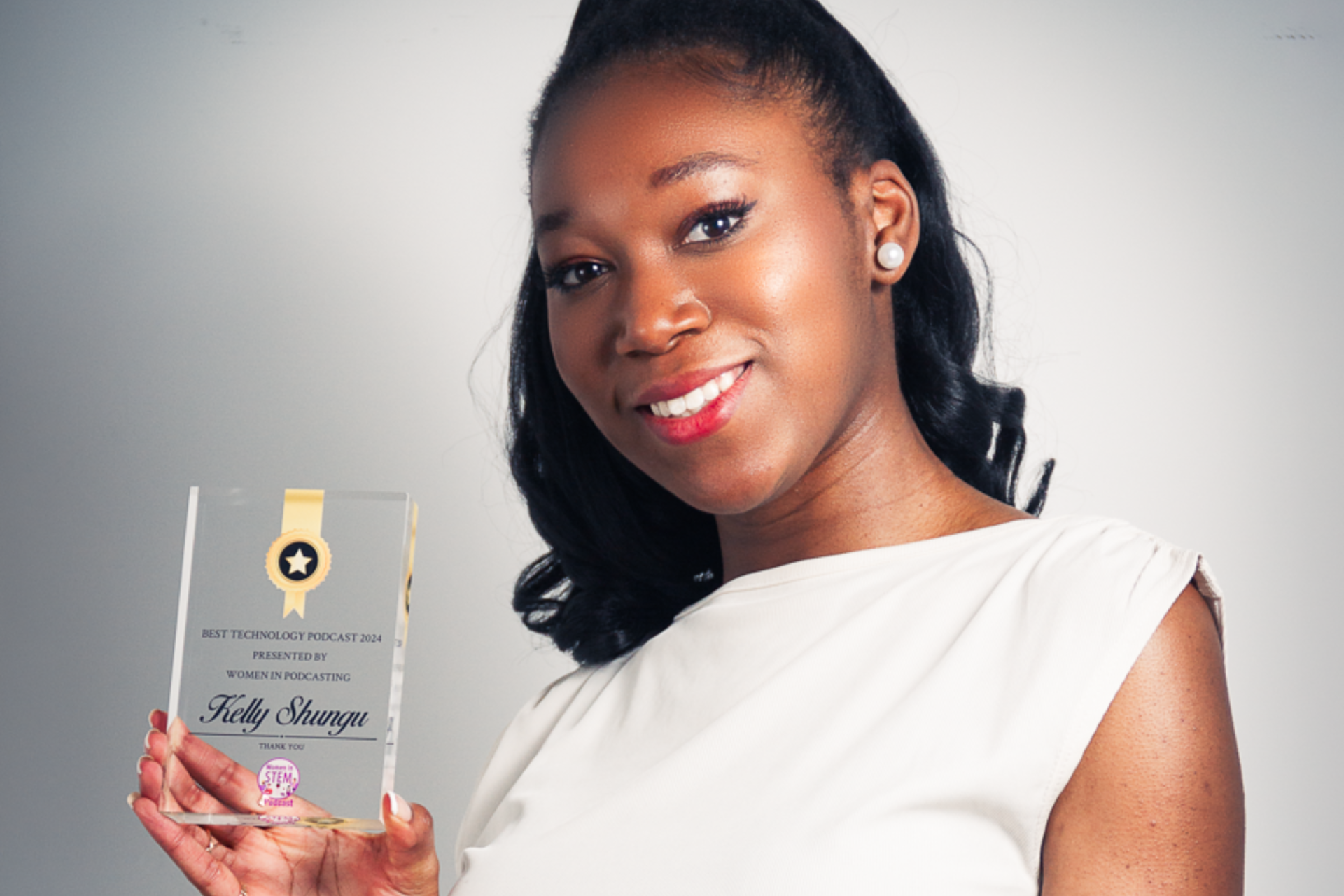 Alumna Kelly Shungu holding best technology podcast award
