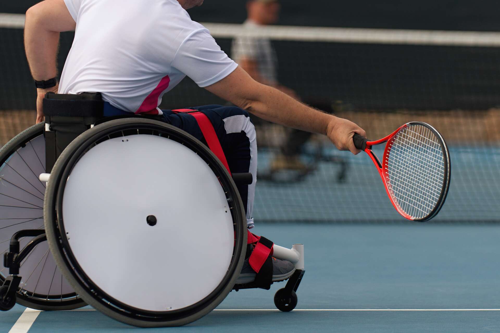 Wheelchair tennis player moving to return the ball during a wheelchair tennis game