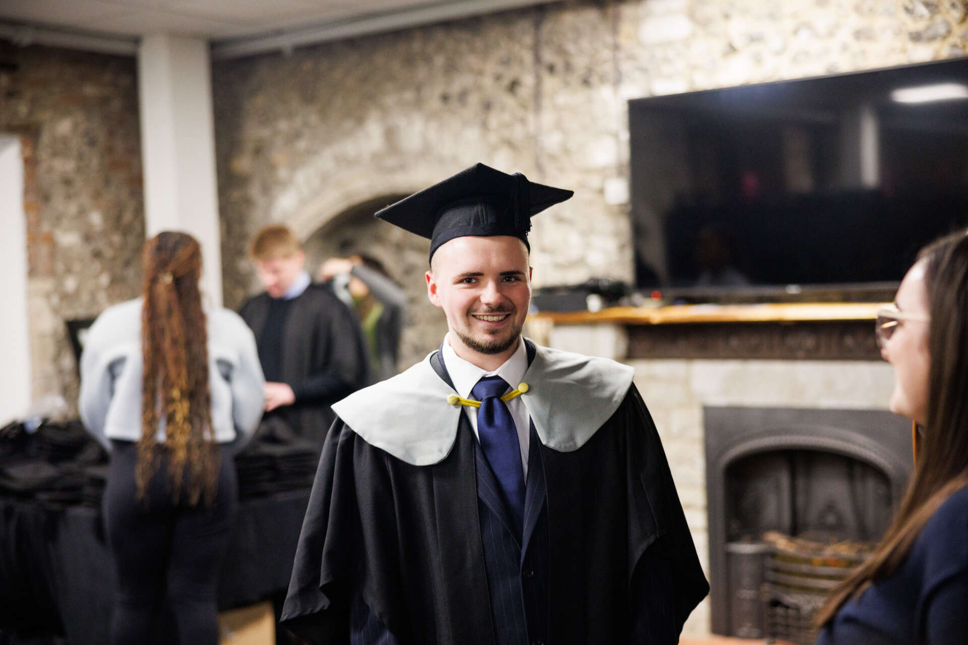 student posing in graduation cap and gown
