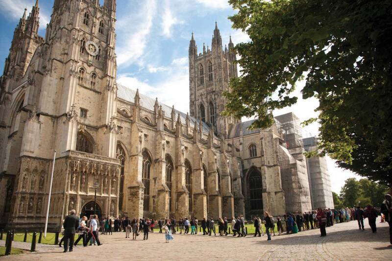 Canterbury Cathedral on a clear day with a queue of visitors waiting to enter