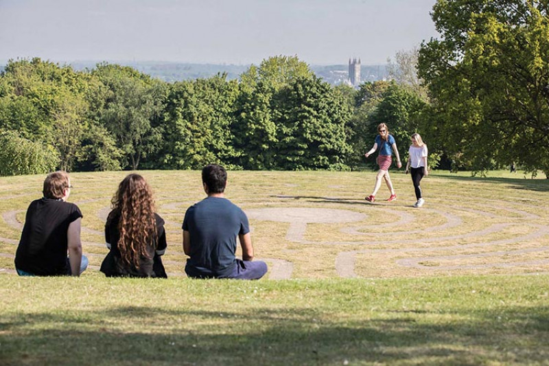 Students sit on the hill overlooking Canterbury city and the Cathedral