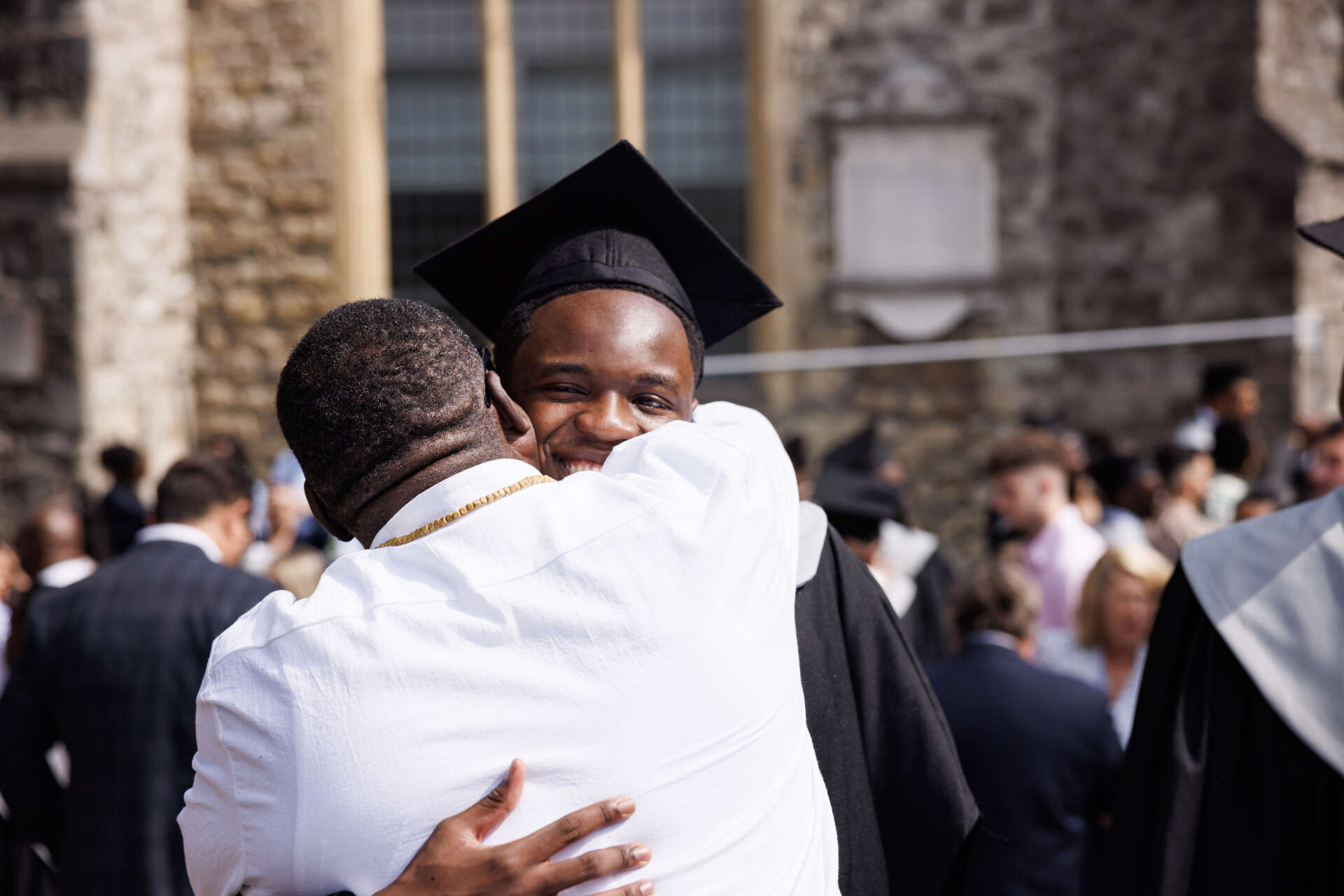 A student being hugged at their graduation