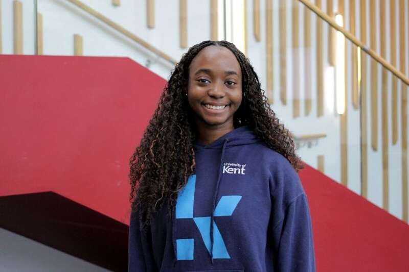 Ike in a blue Kent branded hoodie, posing by the stairs in our Kennedy building.