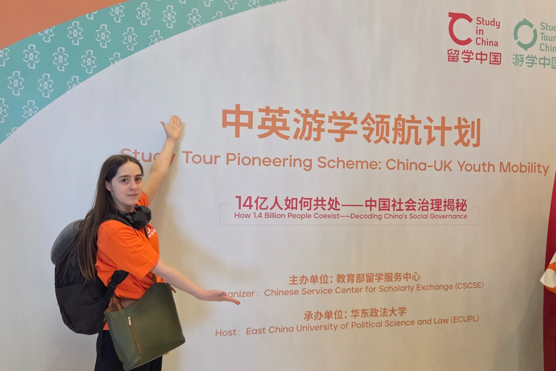 Katie standing next to Study Tour Pioneering Scheme: China to UK sign.