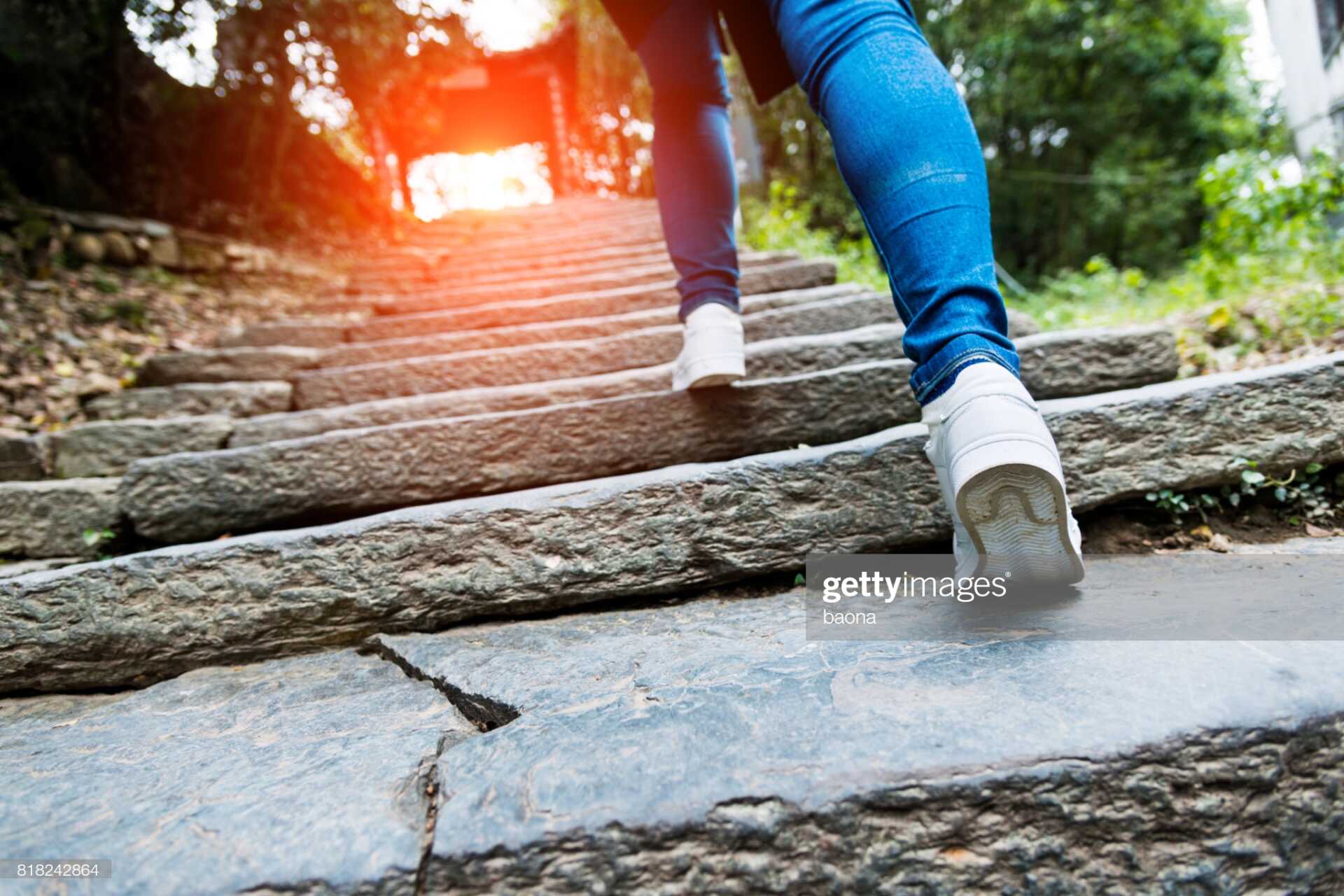 Footsteps up a concrete staircase to a bright light