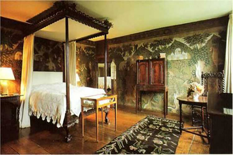 A bedroom decorated with rare late 17th century painted cloths at Owlpen Manor in Gloucestershire