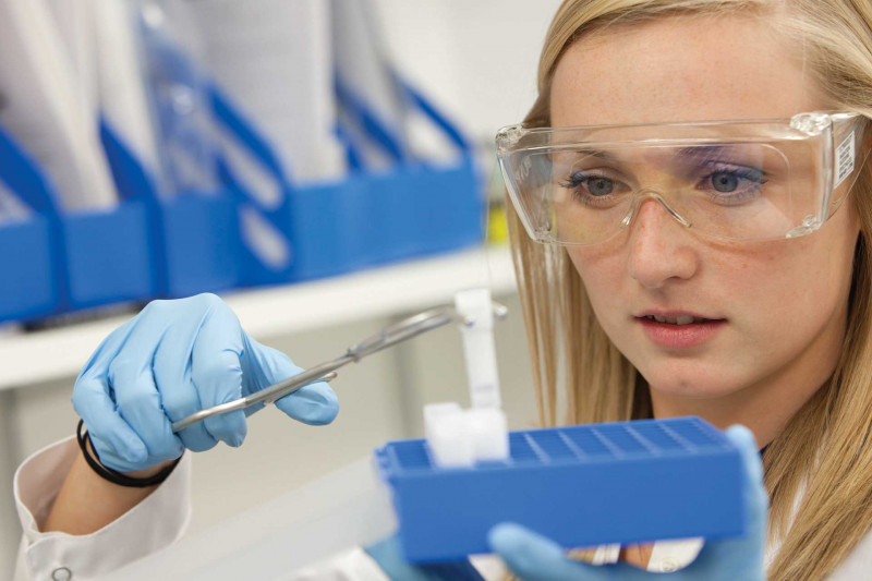 A student holding a test tube with tongs