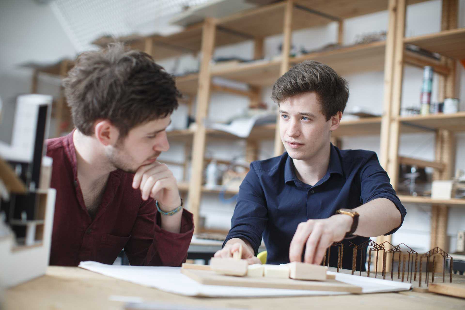 Edward Powe, architecture student, showing a friend a model that he is working on