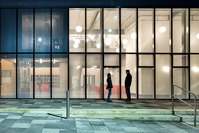 The Jarman Building at night with two people standing outside