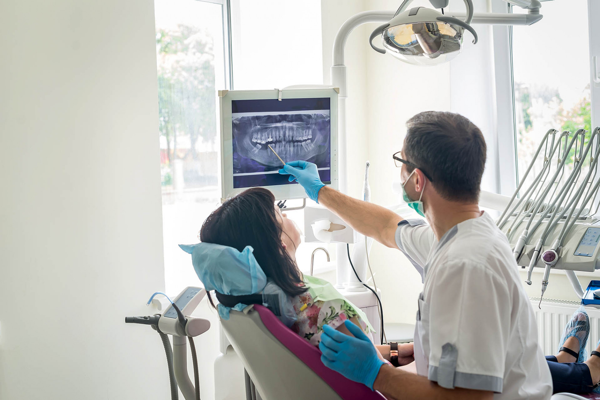A dentist shows a patient an x-ray of her teeth