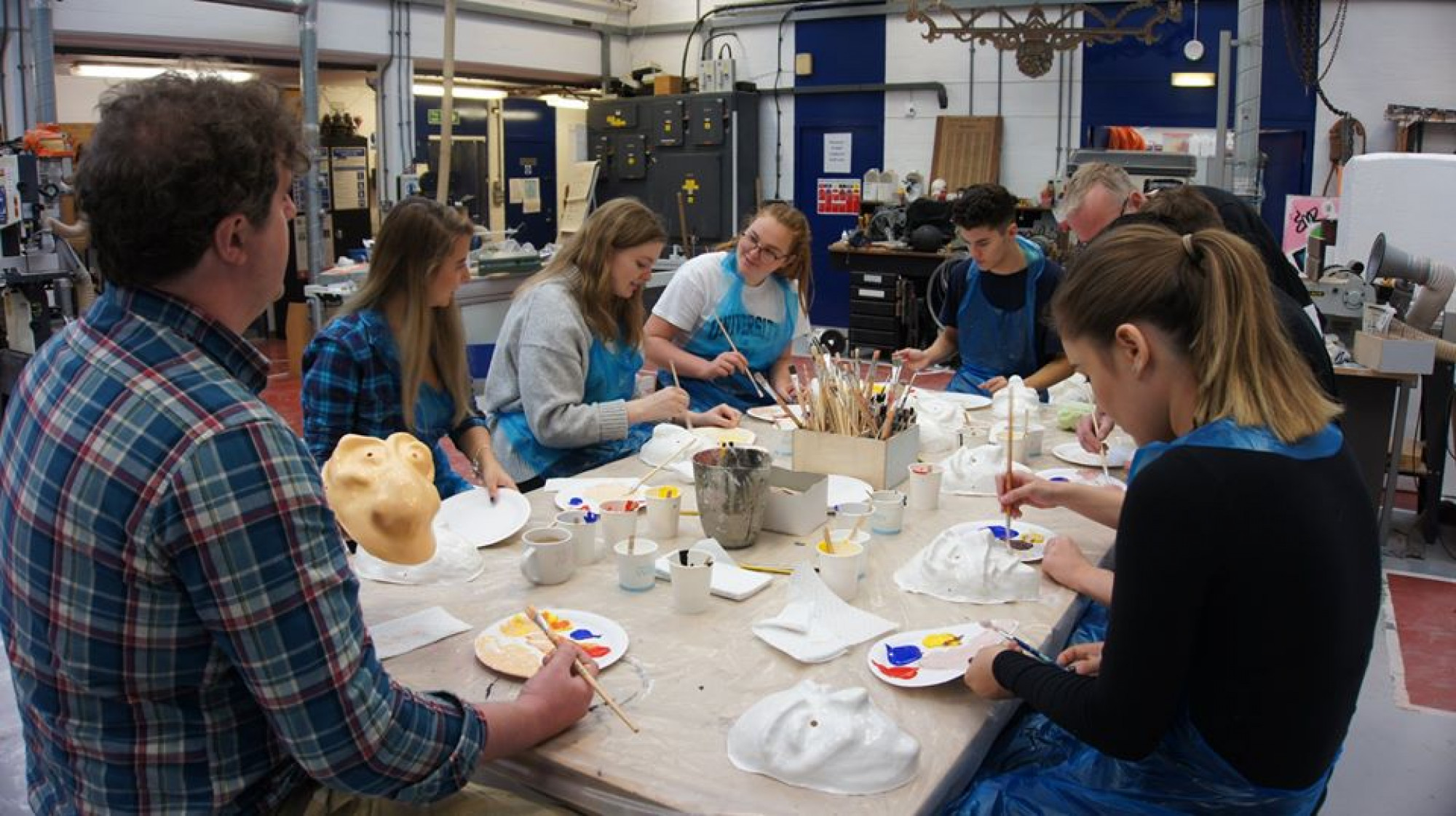 Students painting their masks in the School of Arts dedicated workshop.