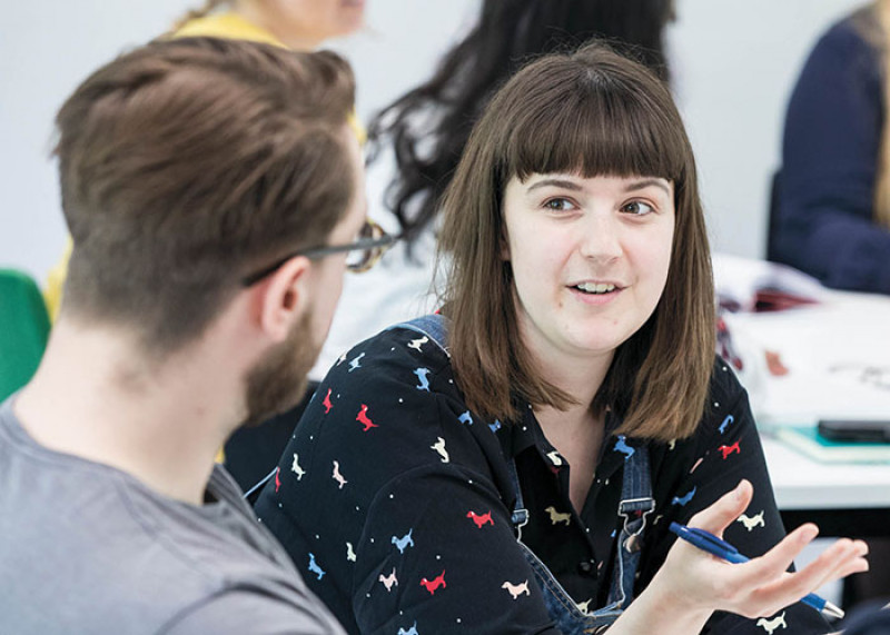 Female staff member giving information to a male student
