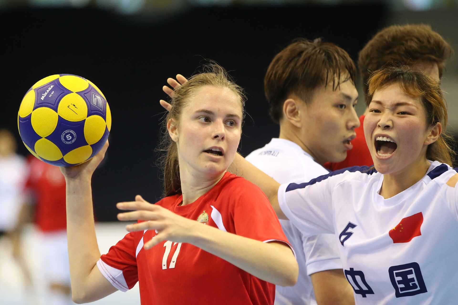 Female korfball player preparing to throw with opposition player behind about to defend