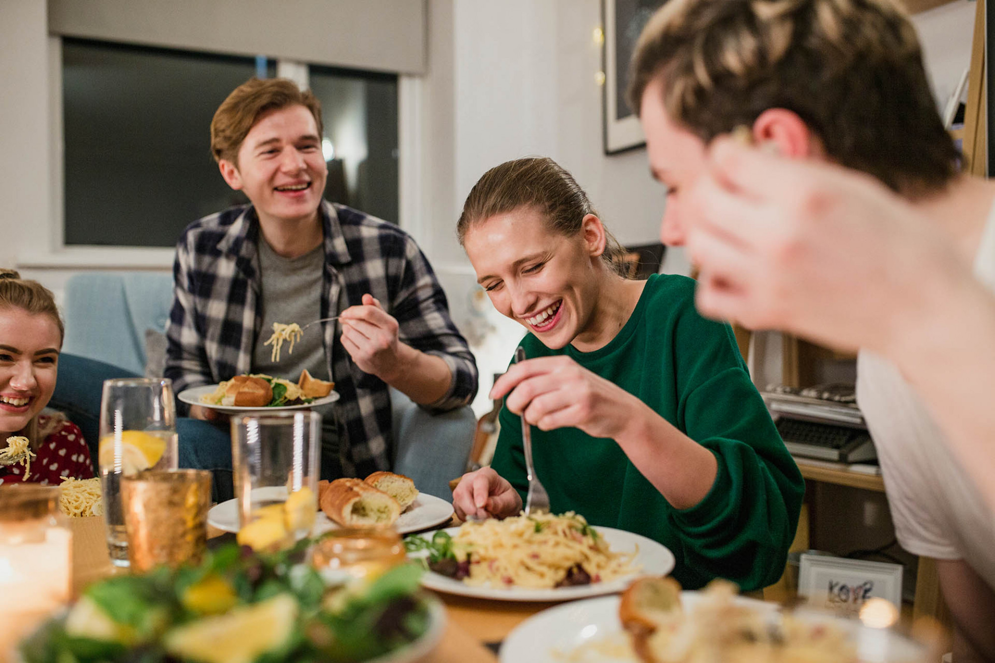 Students laughing eating dinner as group