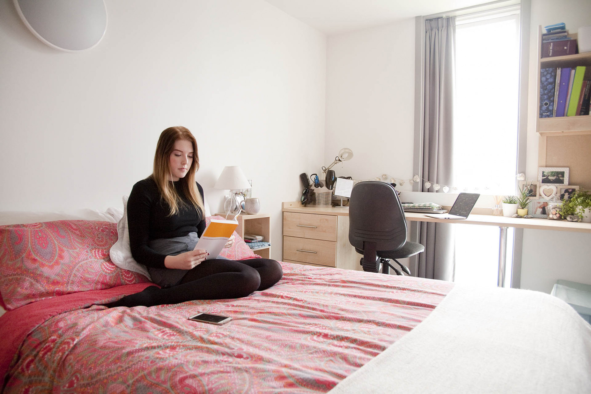 Student reads in an extra large bedroom in Keynes Flats