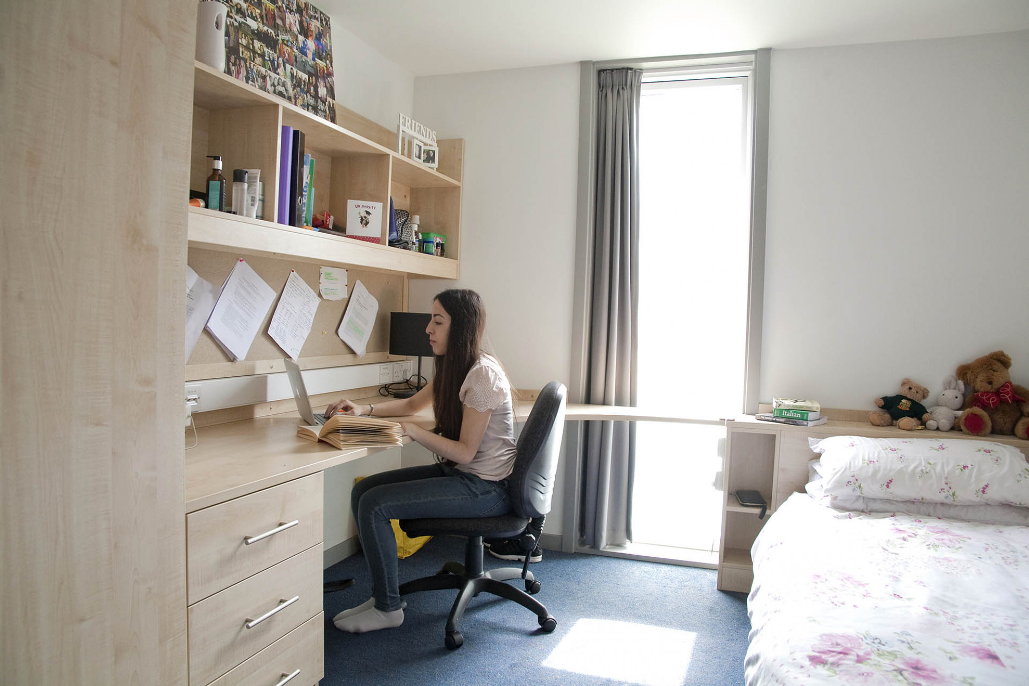 Female student works at her desk in a Keynes House bedroom