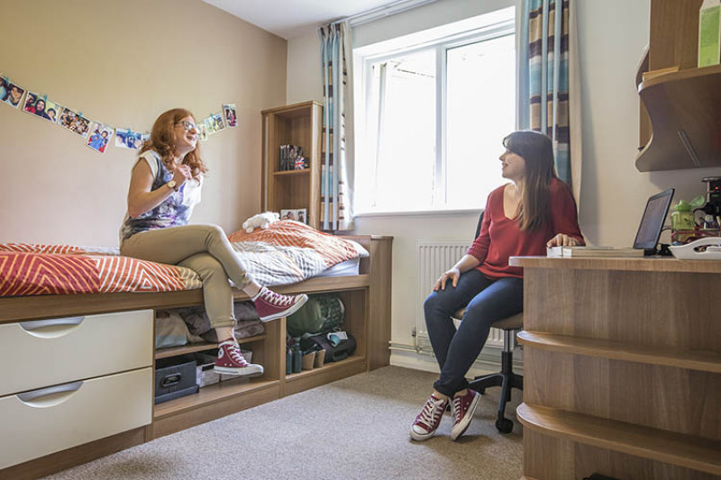 Two female students chat in a Park Wood House bedroom