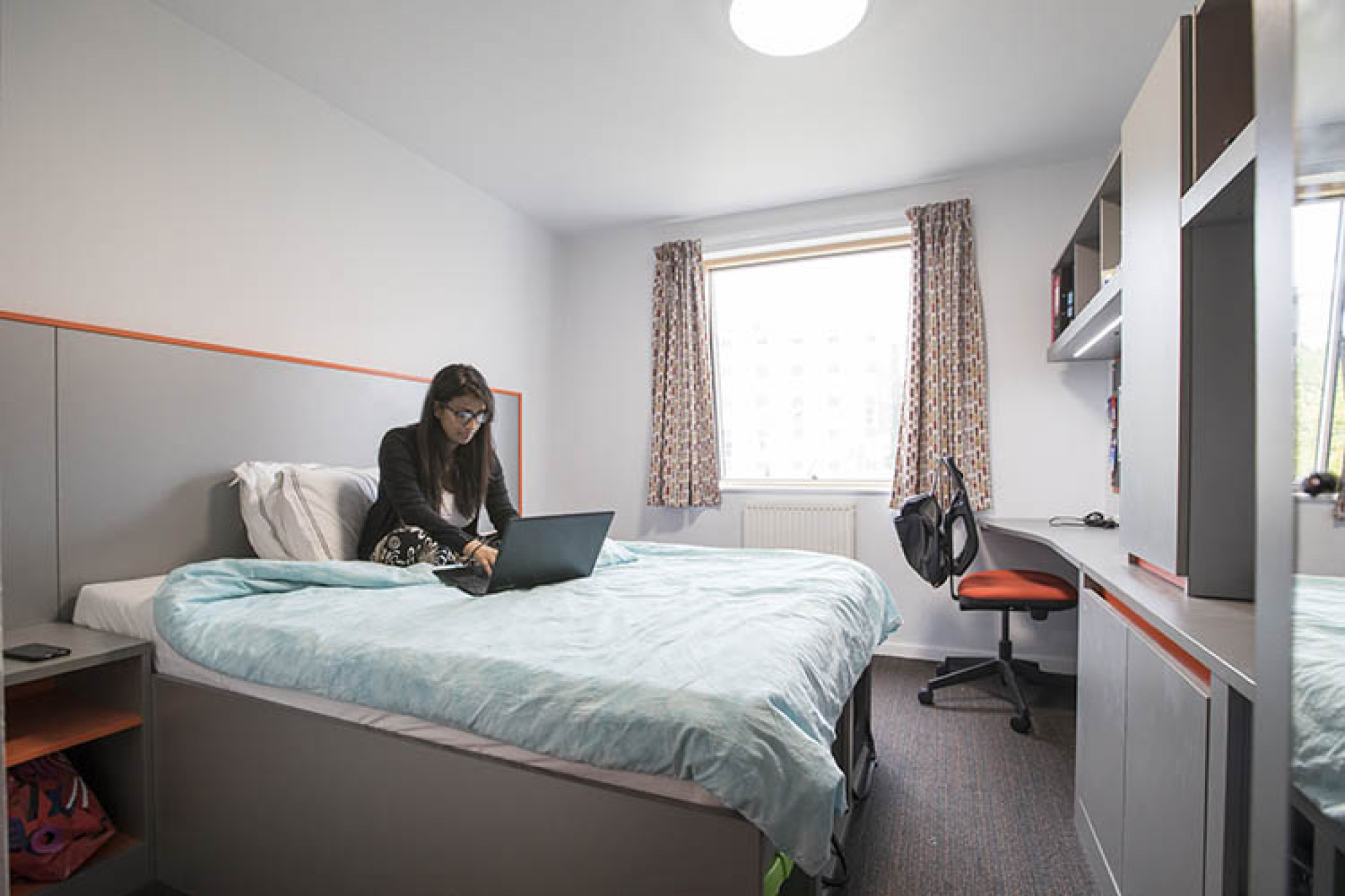 Student works on her laptop in a Tyler Court double bedroom