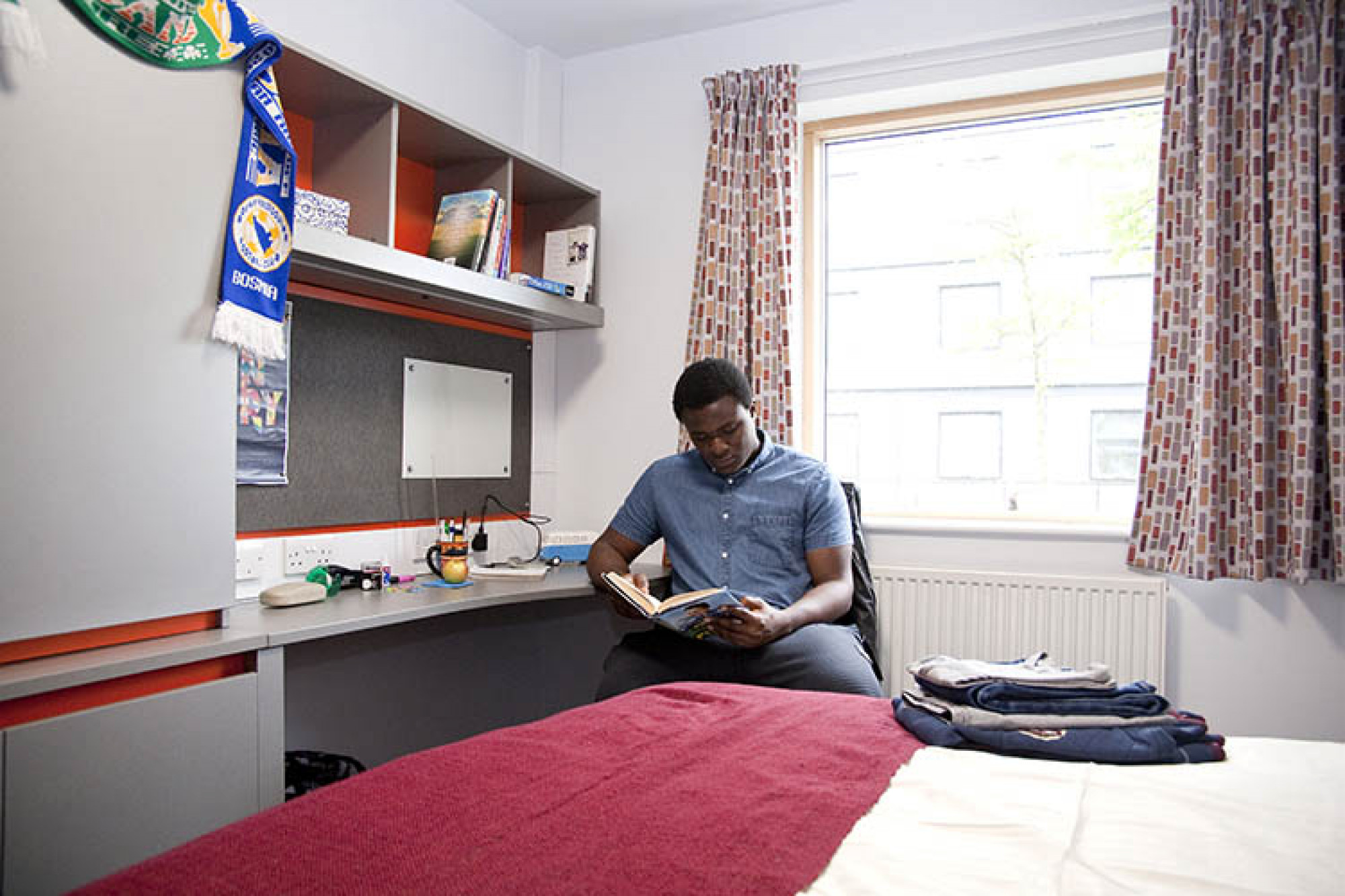 Student reading in a Tyler Court bedroom