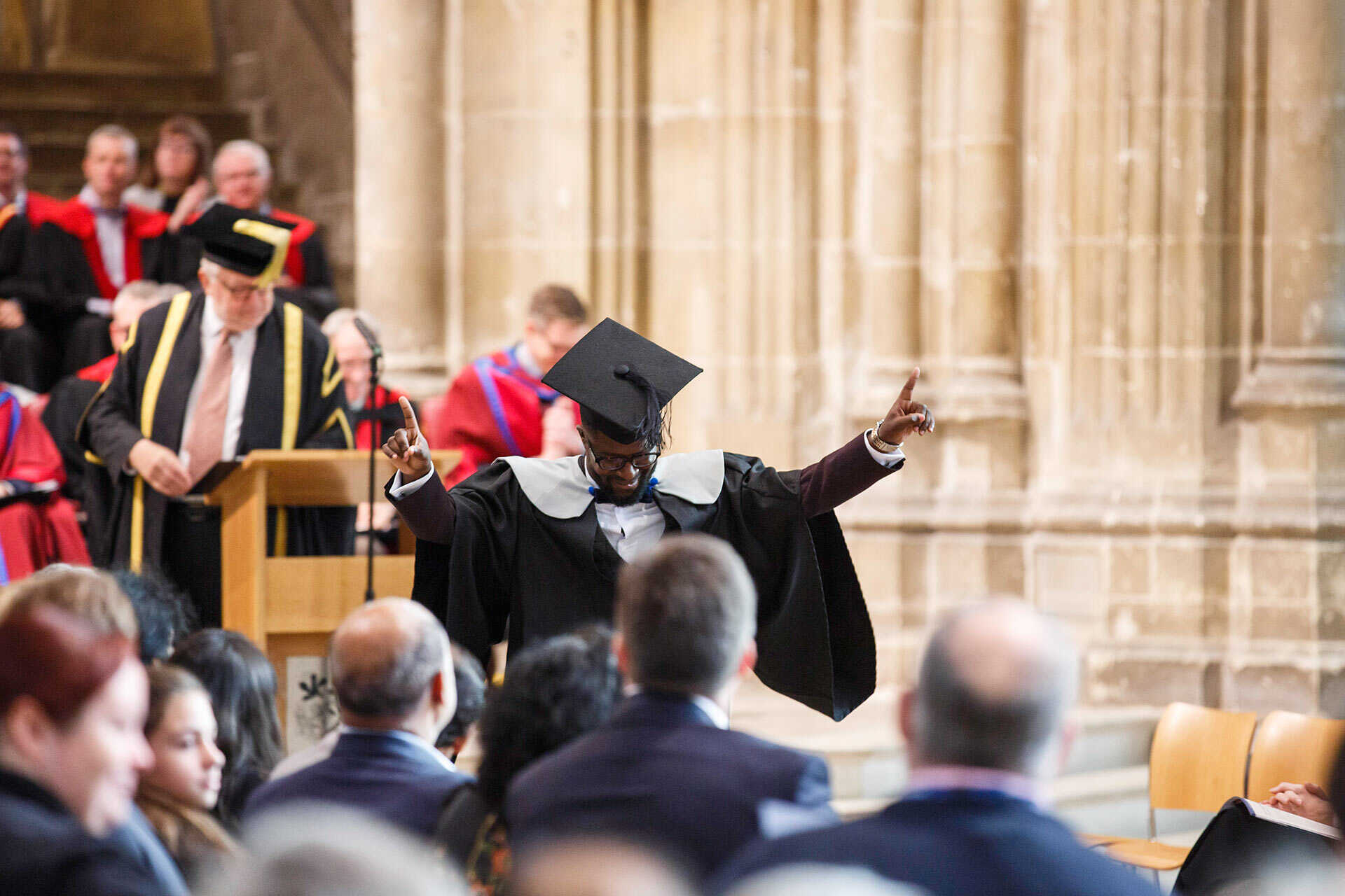 Student walking down the nave of Canterbury Cathedral, celebrating his achievement