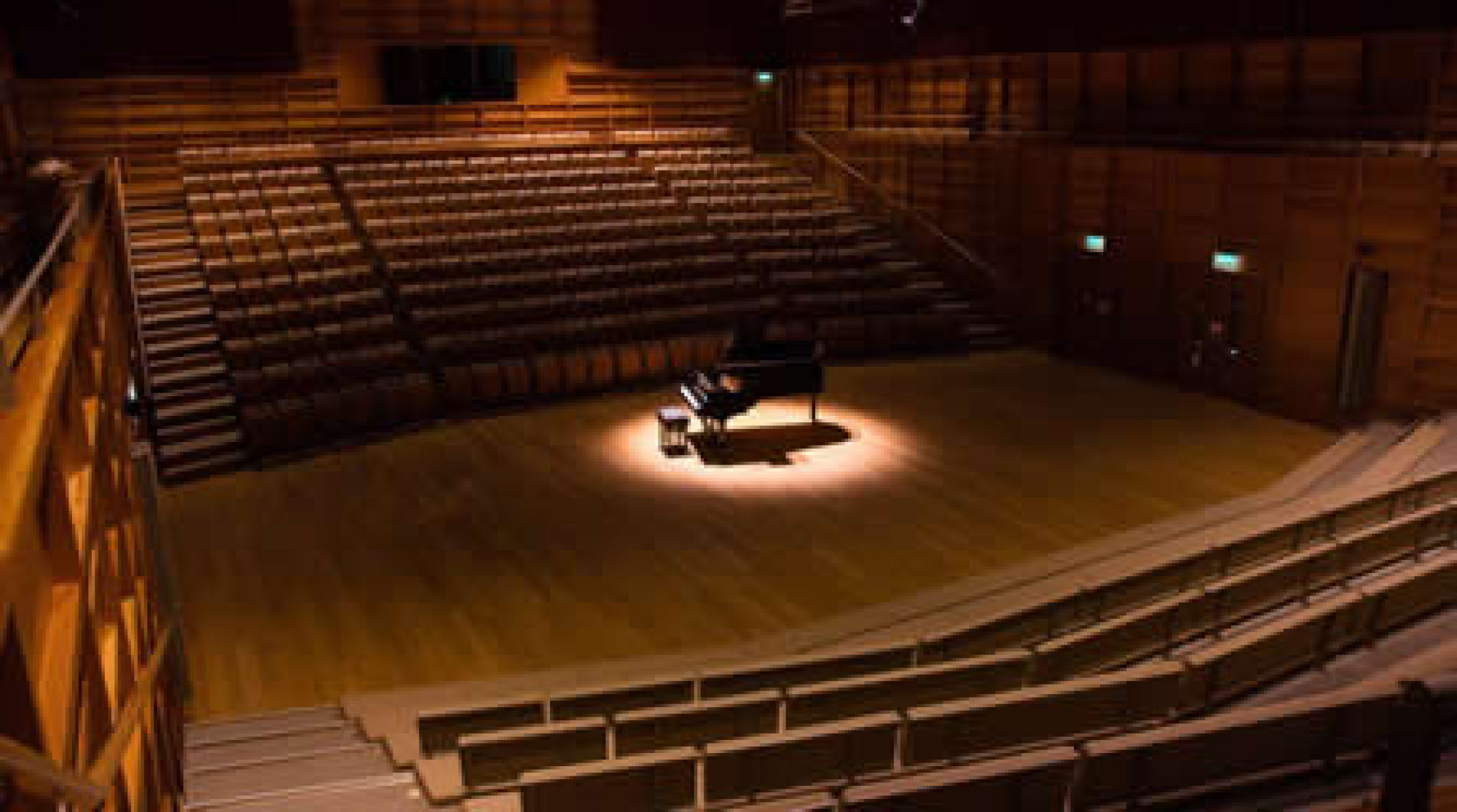 Spotlight on a piano in the Colyer-Fergusson Concert Hall. Image: Molly Hollman