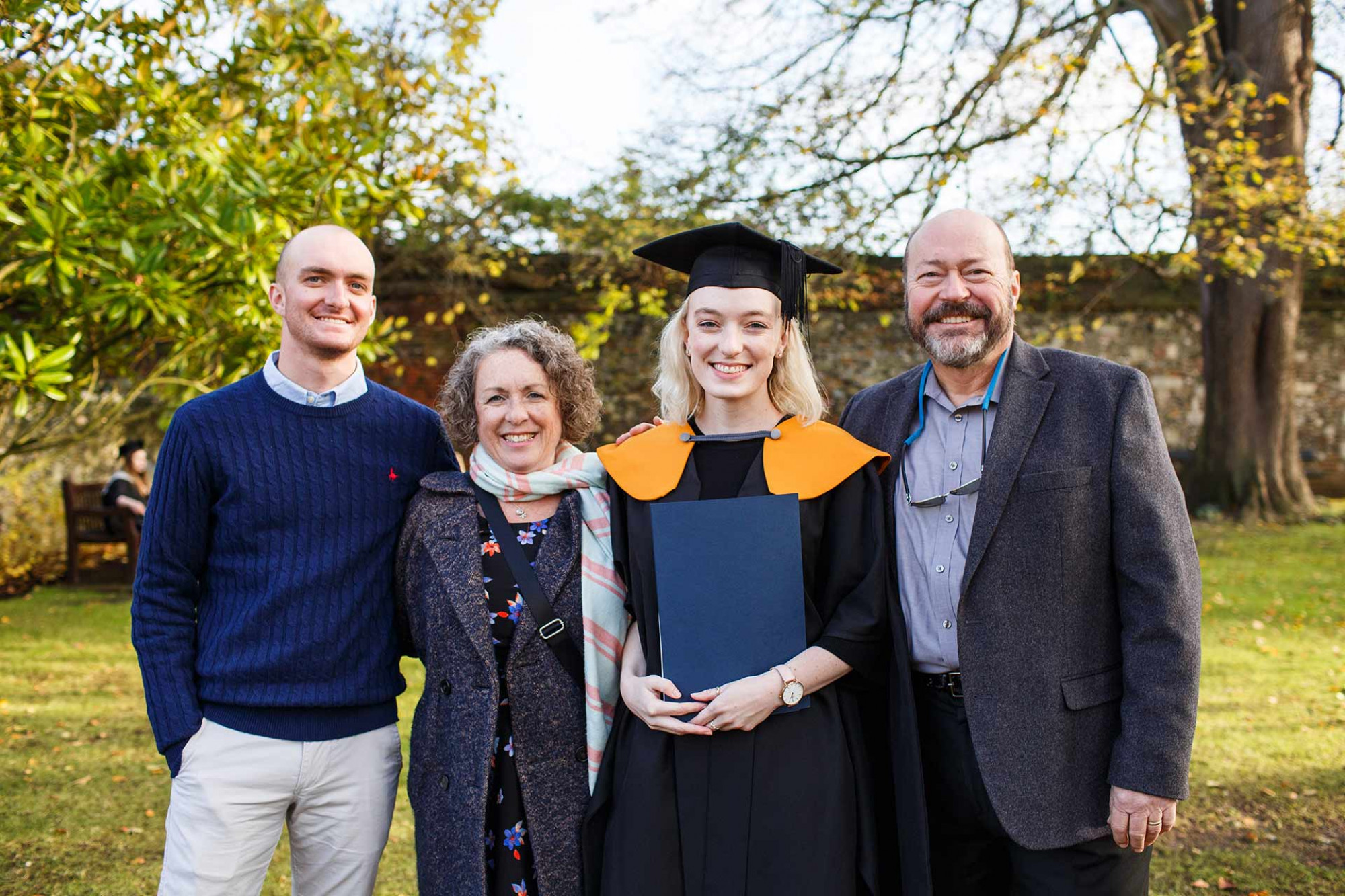 A graduate with her guests looking at the camera